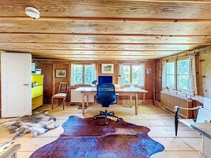 A rustic cabin interior with a wooden ceiling, a desk with a computer, a chair, and a large fur rug on the floor. - Winterberg by Interhome (Feldberg)