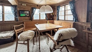 A cozy wooden cabin with a dining table, chairs, and a large window. - Winterberg by Interhome (Feldberg)