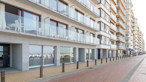 A modern multi-story hotel with balconies, large windows, and a brick-paved walkway. - Westcliff I with seaview by Interhome (Blankenberge)