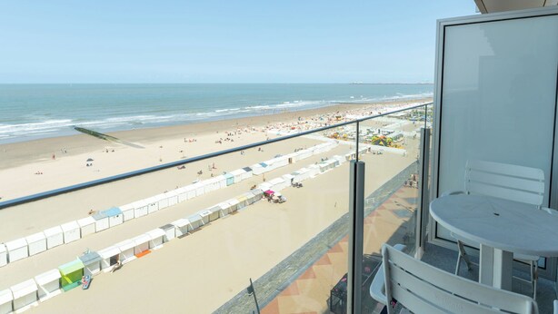 A balcony with a view of a beach, including a sandy area with umbrellas and tents, and the ocean. - Westcliff I with seaview by Interhome (Blankenberge)