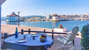 A table set for dining with a view of a harbor and buildings in the background. - Coudalère/Les Hébrides by Interhome (Le Barcarès)