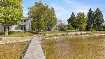 A residential area with a clear water body, a wooden dock, and houses with balconies.