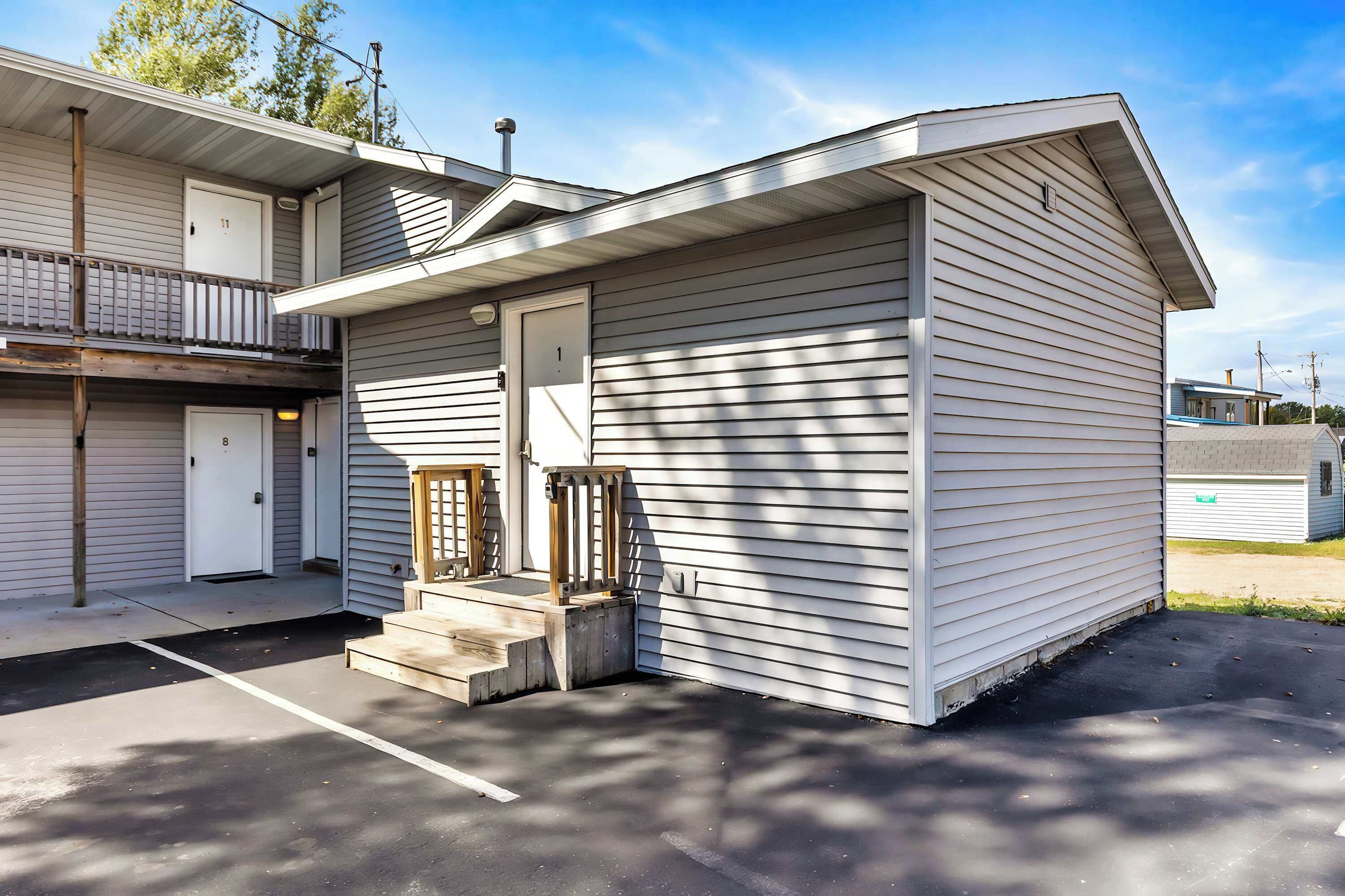 Una construcción de un piso con porche delantero y puerta de garaje.