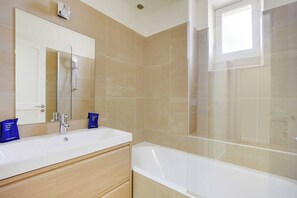 A modern bathroom with a large mirror, a bathtub, and a shower. - Apt a/c 3br/6p - Saint-lazare/les Champs Elysee (Paris)