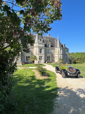 A large stone building with a driveway and a vintage car parked in front. - Whole cottage - 2 bedrooms (Mauges-sur-Loire)