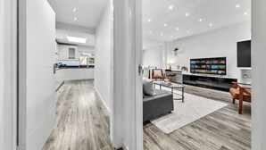 A modern living room with a grey sofa, a coffee table, and a flat-screen TV. - 5 Bedrooms house near Wembley StadiumI Free parking I Discounts for Longer Stays (Wembley)