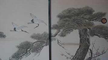 Una pintura china tradicional con grullas volando y un pino con flores.