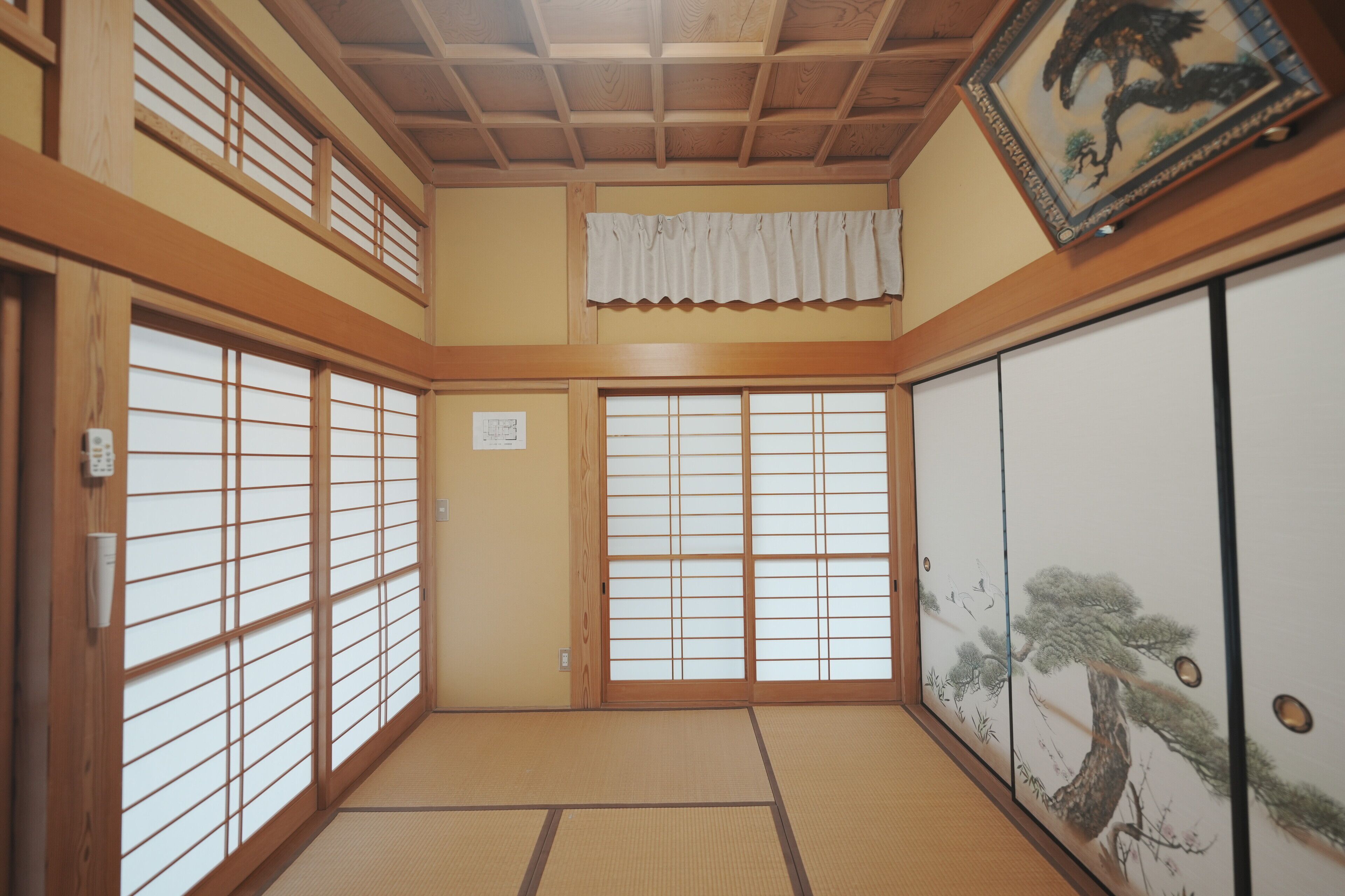 A traditional Japanese room with tatami flooring, sliding doors, and a shoji screen.