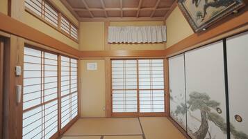 A traditional Japanese room with tatami flooring, sliding doors, and a shoji screen.