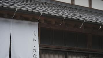 Un edificio japonés tradicional con tejado de tejas y una pancarta blanca con caracteres japoneses.