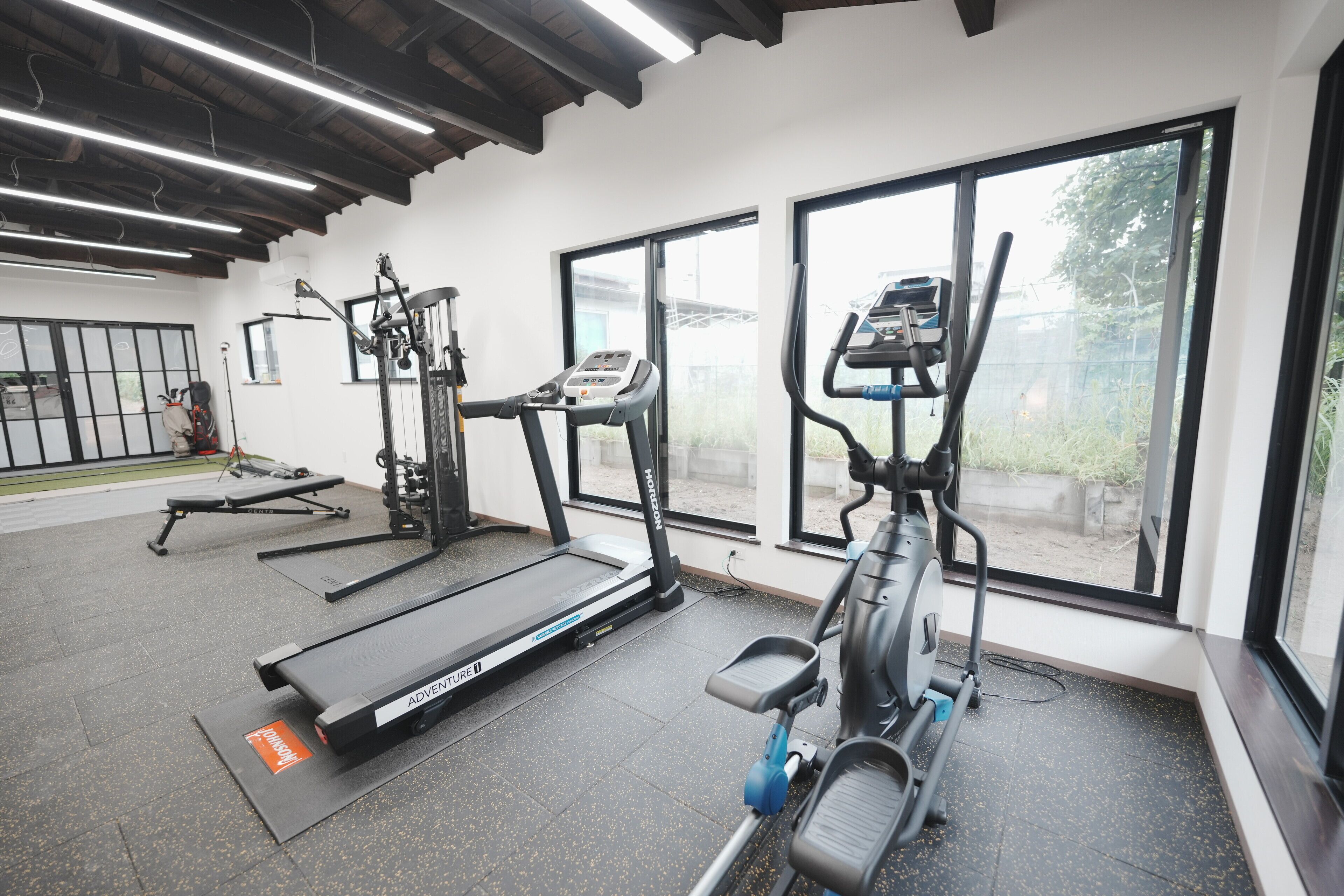 A gym with treadmills, elliptical machines, and weight equipment.