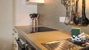 Een keuken met een roestvrijstalen fornuis, een spoelbak en een aanrecht.