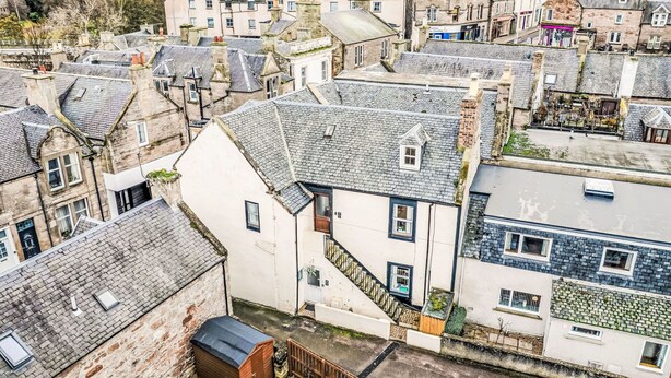 A high-angle view of a historic town with closely packed buildings, steeply pitched roofs, and a mix of stone and brick construction. - Beautiful apartment for 4 people with WIFI and TV (Nairn)