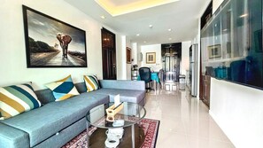 A modern living room with a sofa, coffee table, and a painting of an elephant.