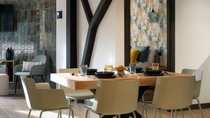 A modern dining area with a wooden table, four chairs, and a decorative wall with geometric patterns.