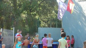 A group of children playing near a pool with a blue fence and trees in the background. - Mobile home with terrace in Bormes-les-Mimosas (Bormes-les-Mimosas)