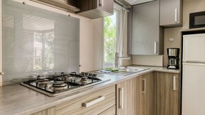Eine moderne Küche mit Gasherd, Holzschränken, Mikrowelle und Kaffeemaschine.
