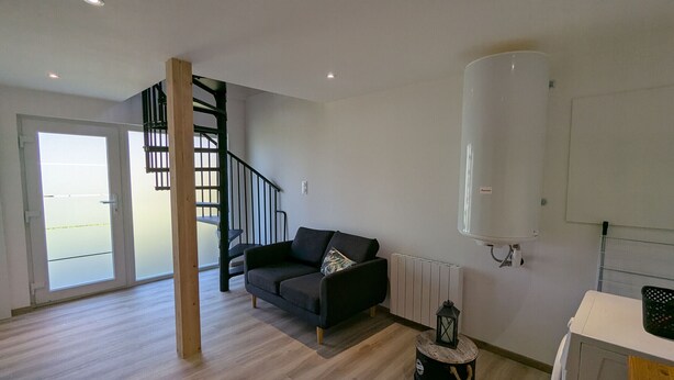 A modern living room with a staircase, a sofa, a radiator, and a white cabinet. - House for 4 in Gérardmer between lake and mountains with terrace (Gérardmer)