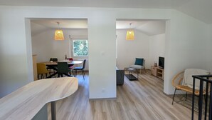 A modern, open-plan living space with a dining area, a seating area, and a television. - House for 4 in Gérardmer between lake and mountains with terrace (Gérardmer)