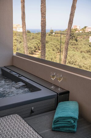 A spa area with a hot tub, two glasses of wine, and a teal towel. - Kymélia Upper Suite With Private Hot Tub & SeaView (Galatas)