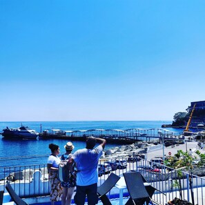 A seaside view with a pier, boats, and a clear sky.