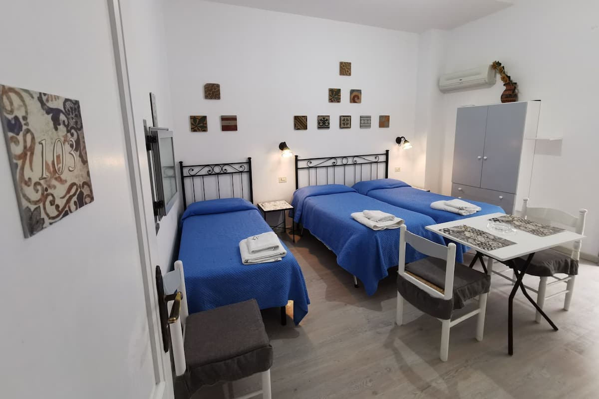 A room with two beds, a desk, and a wardrobe.