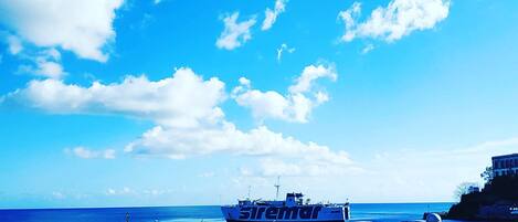 A ferry named 'Siremar' docked at a port with a clear blue sky and calm sea.