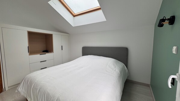 A bedroom with a skylight, a bed, a wardrobe, and a green wall. - LePtiLoft Bayeux (Bayeux)