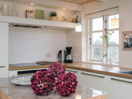 Una cocina moderna con cafetera, un lavamanos y una ventana con vistas.