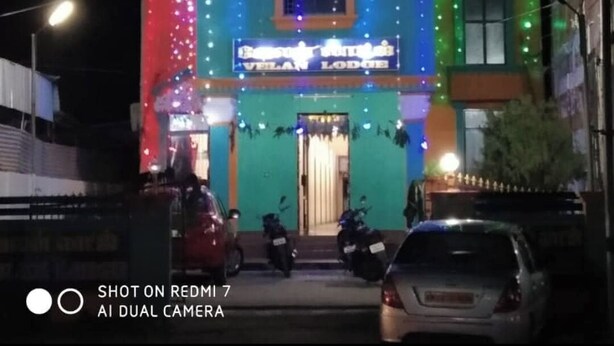 Un edificio con un letrero que dice "Velan Lodge" y varias ventanas, rodeado de luces de colores.