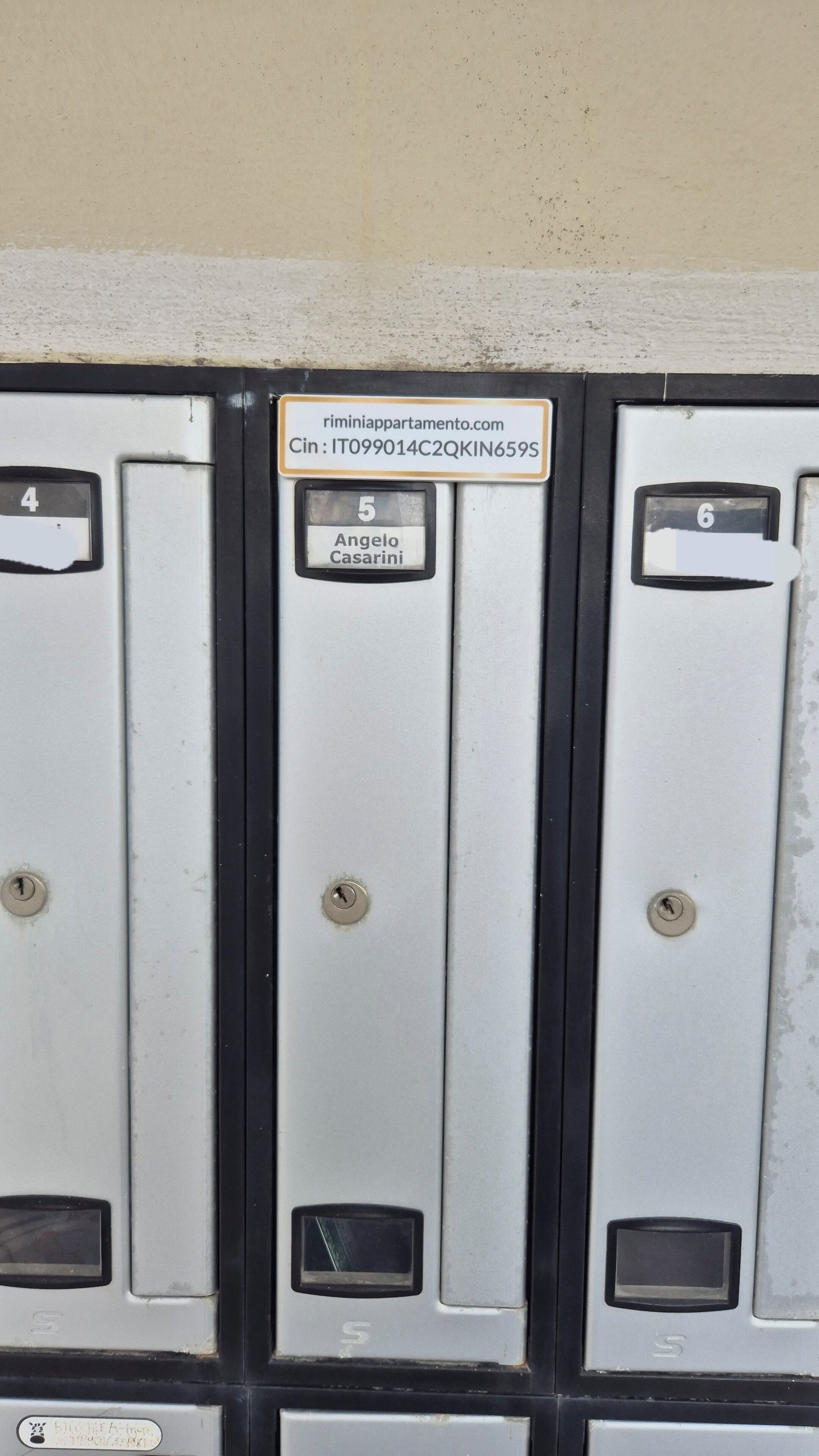 A row of numbered mailboxes with a sign above them.