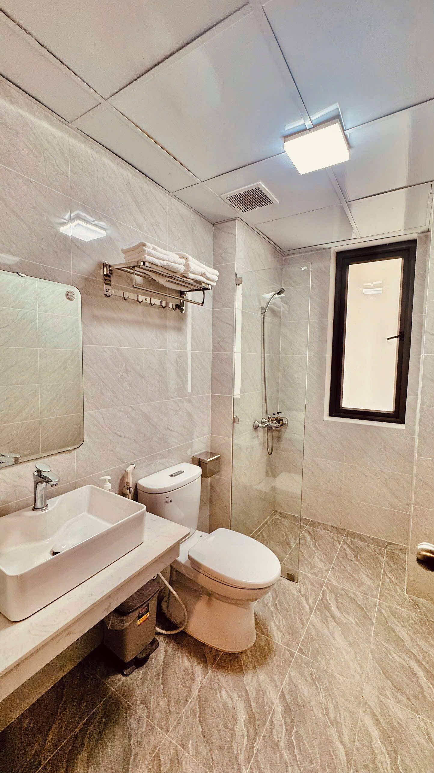 Une salle de bain moderne équipée d’un lavabo, de toilettes et d’une douche.