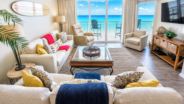 A living room with a view of the ocean, a ceiling fan, and a television. - Crescent Shores S 1210 - Oceanfront Luxury & Unmatched Views! (North Myrtle Beach)