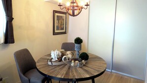 A dining area with a round table, chairs, a chandelier, and decorative items. - MAISON DE AILE (Takasaki)