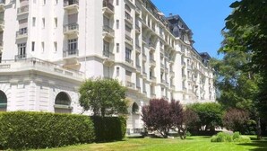 A large, multi-story hotel with a classic architectural style, featuring balconies and a well-maintained lawn in front. - Facing the Mont Blanc range. (Chamonix-Mont-Blanc)