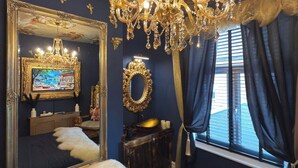 A luxurious bedroom with a large bed, ornate chandelier, and a ceiling mural. - The Lobster Pot Scarbrough luxury Holiday Let (Scarborough)