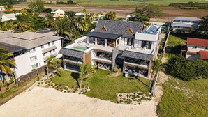 A modern two-story house with a large balcony, a swimming pool, and a well-maintained lawn. - CasaWapa - Waterfront Apartment (Pointe d'Esny)