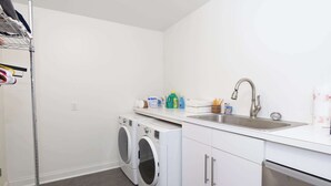 A laundry room with a washing machine, dryer, and a sink with toiletries. - Touchdown at Tanglewood by Apex Short Term Stays (Oxford)
