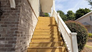 A wooden staircase leading to a white porch with a brick wall on one side. - Touchdown at Tanglewood by Apex Short Term Stays (Oxford)