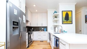 A modern kitchen with white cabinetry, a stainless steel refrigerator, a built-in oven, and a white countertop. - Touchdown at Tanglewood by Apex Short Term Stays (Oxford)