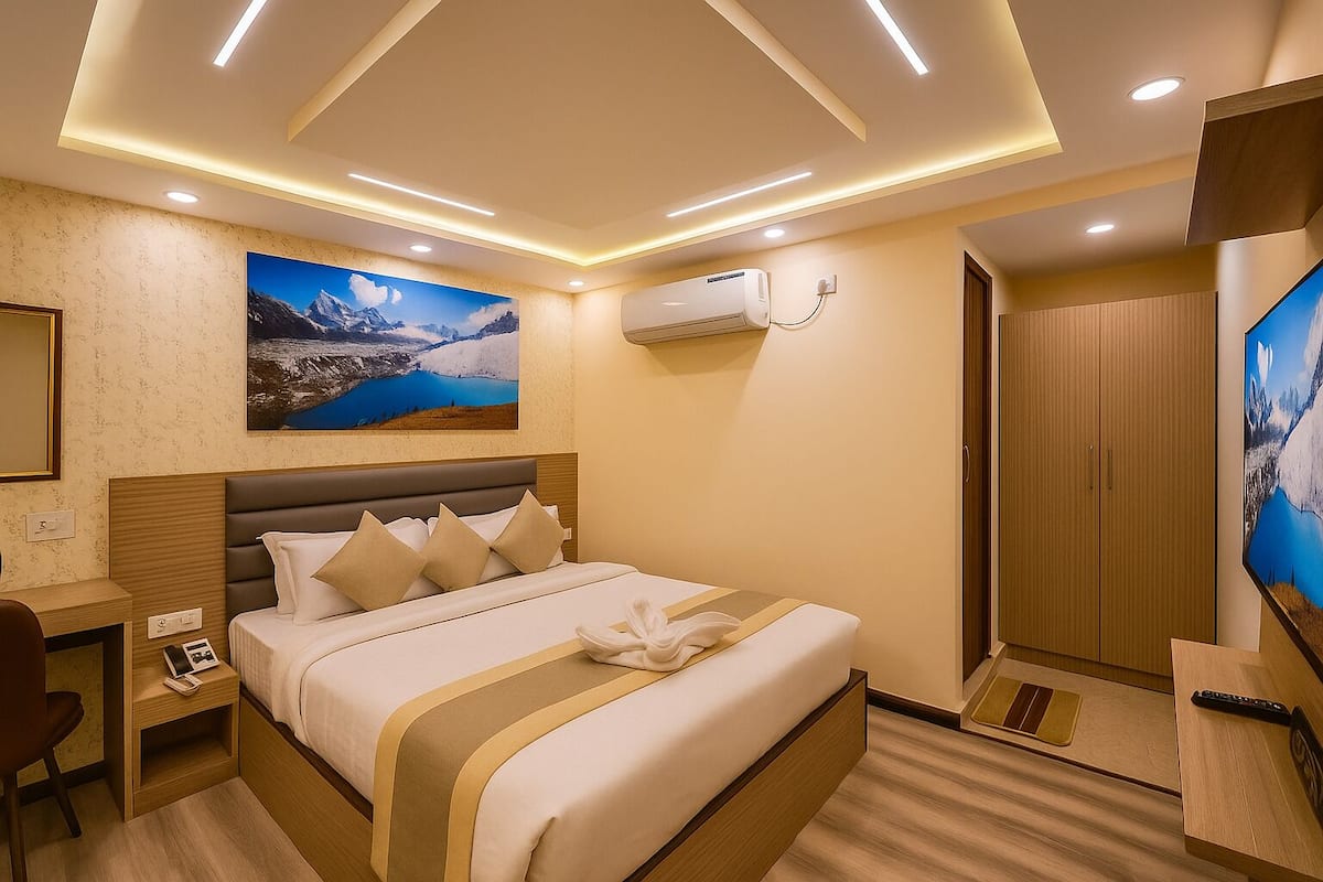 A hotel room with a bed, a desk, a TV, and an air conditioning unit.