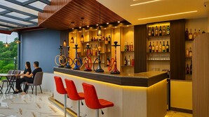 A modern bar area with a counter, red bar stools, and a variety of bottles. - Kathmandu Royal Chamber Hotel (Kathmandu)