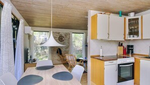 A compact kitchen with a dining area, wooden ceiling, and a view through the window. - 6 Person Holiday Home in Hojby (Hojby)