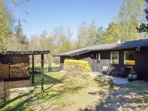 A wooden cabin with a covered porch and a patio area. - 6 Person Holiday Home in Hojby (Hojby)