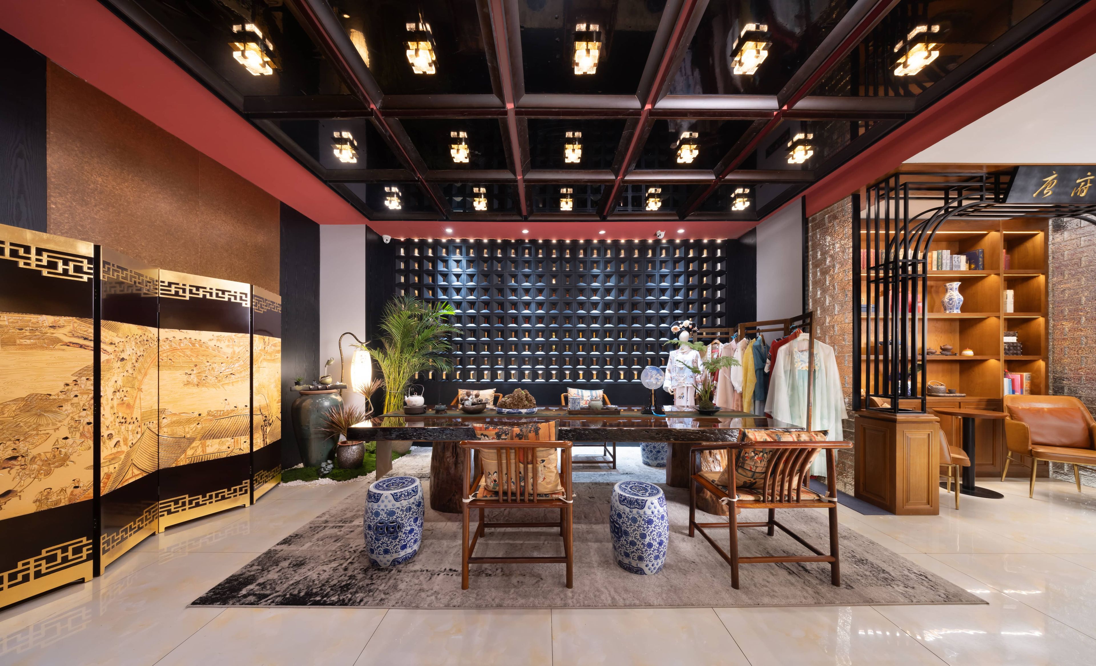A modern interior with a central seating area, a decorative wall with a geometric pattern, and a bookshelf with various items.