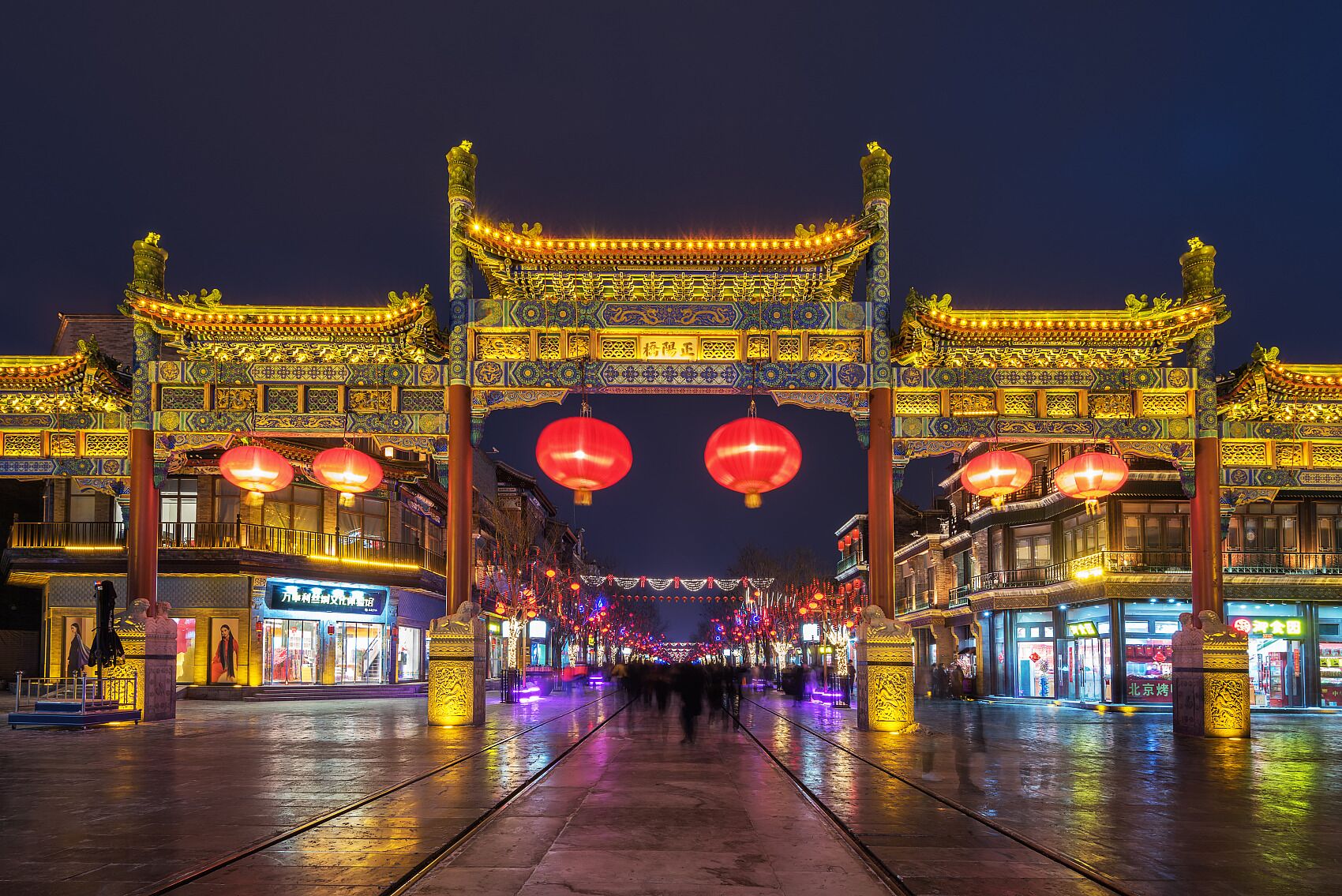 A traditional Chinese gate with ornate decorations and red lanterns.