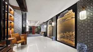 A modern lobby with a polished floor, seating area, and decorative wall art. - Beijing TangFu Chinese Culture Boutique Hotel Sanlitun Embassy Area (Beijing)