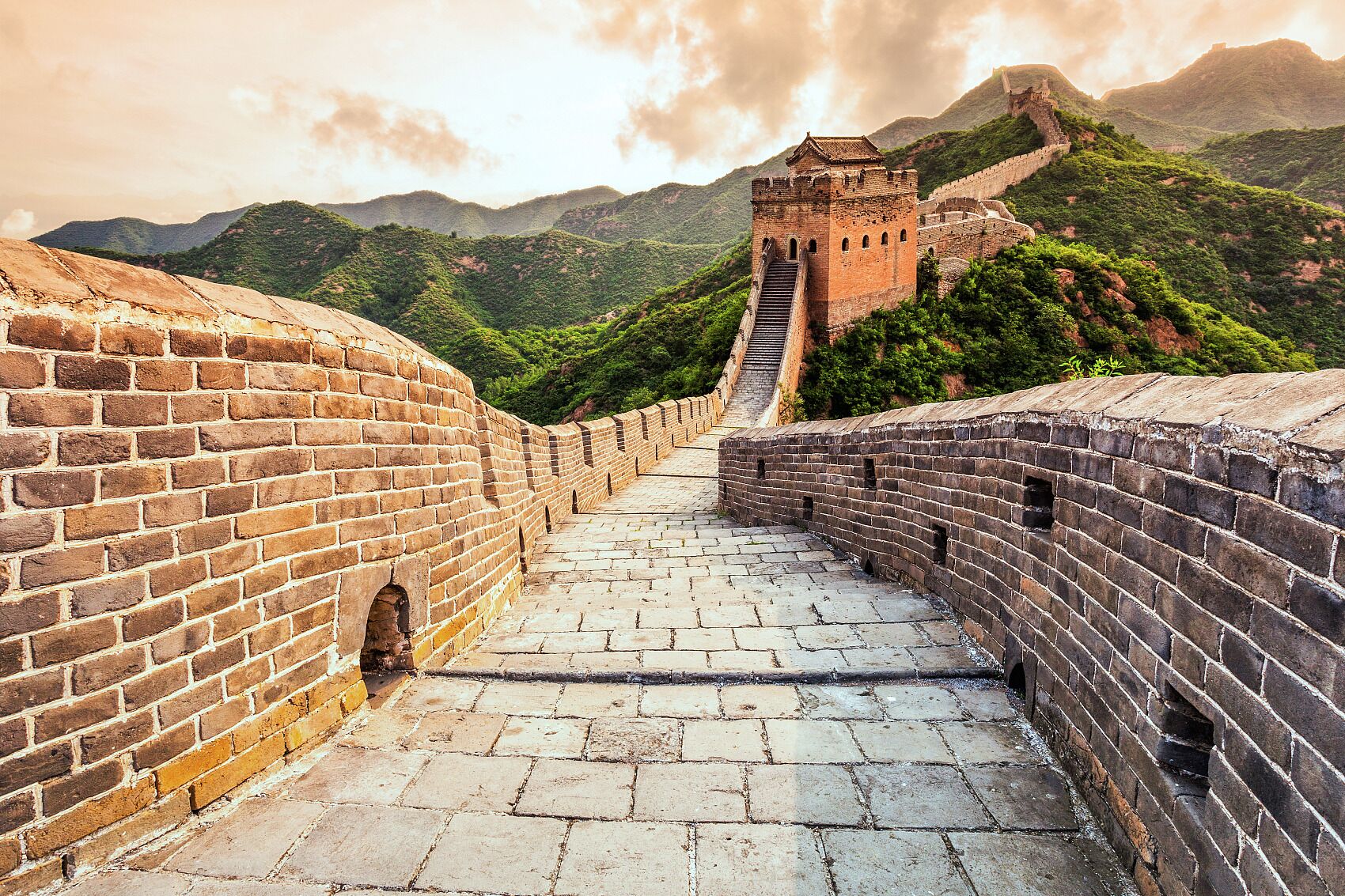 Un tramo de la Gran Muralla China con una torre de vigilancia y una escalera que lleva a ella.