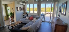 A modern living room with a sofa, a coffee table, and a view of the outdoors. - Spacious villa with pool and views of the sea and garrigue (Frontignan)