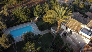 An aerial view of a property with a swimming pool, a stone building, and surrounding greenery. - Charming farmhouse nestled in the Iblea countryside. Pet Friendly (Sicilia)